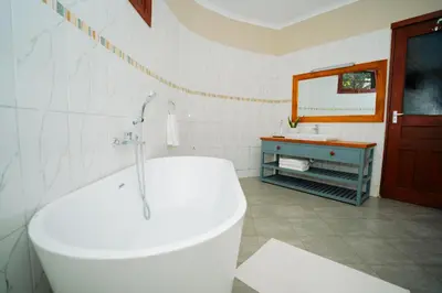 a white bathroom with a tub and a sink at Arusha Planet Lodge in Arusha