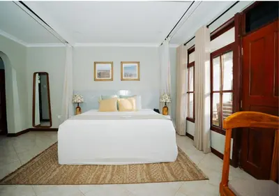 a white bedroom with a large white bed in it at Arusha Planet Lodge in Arusha