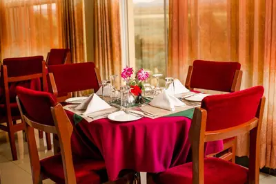 a table with red chairs and a pink table cloth at A1 Hotel and Resort in Arusha