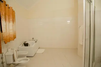 a white bathroom with a toilet and a sink at A1 Hotel and Resort in Arusha