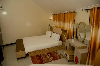 a small bedroom with a bed and a mirror at A1 Hotel and Resort in Arusha