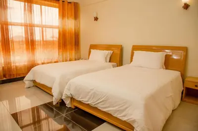 two beds sitting next to each other in a bedroom at A1 Hotel and Resort in Arusha