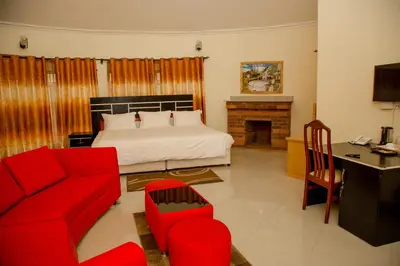 a living room with a bed and a red couch at A1 Hotel and Resort in Arusha