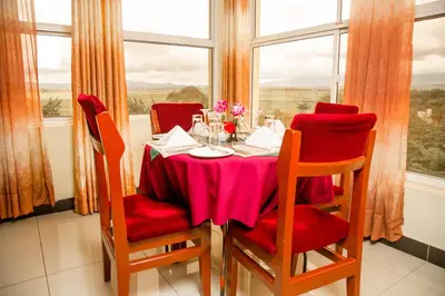 a dining room table with red chairs and a pink table cloth at A1 Hotel and Resort in Arusha