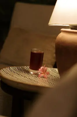 a glass of tea sitting on a table next to a lamp at Tulia Retreat Hotel and Spa in Arusha