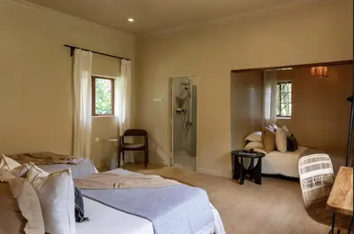 a hotel room with two beds and a shower at Tulia Retreat Hotel and Spa in Arusha
