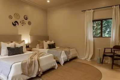 a bedroom with two beds and a window at Tulia Retreat Hotel and Spa in Arusha