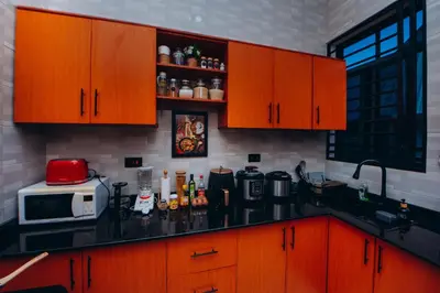 a kitchen with wooden cabinets and a counter top at Royal Homestay in Arusha