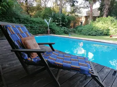 a chair sitting next to a swimming pool at Meru House Lekisilai in Arusha