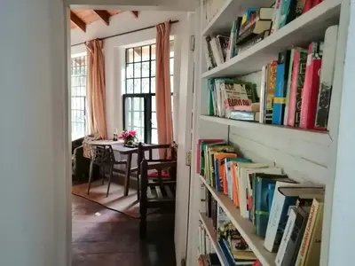 a hallway with book shelves filled with books at Meru House Lekisilai in Arusha