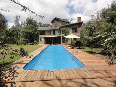 a swimming pool in front of a house at Meru House Lekisilai in Arusha