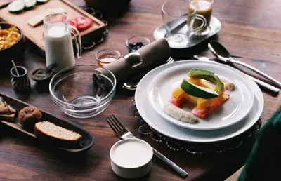 a wooden table with a plate of food on it at Meru House Lekisilai in Arusha