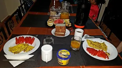 a table with plates of breakfast food on it at The House of Black and White in Arusha
