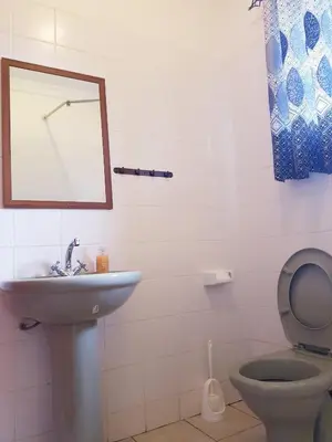 a bathroom with a sink and a toilet and a mirror at The House of Black and White in Arusha