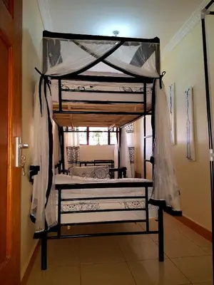 a bedroom with a canopy bed in a room at The House of Black and White in Arusha