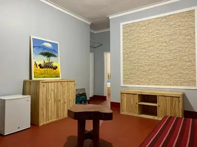 a room with a table and a painting on the wall at Pazuri Hostel in Moshi