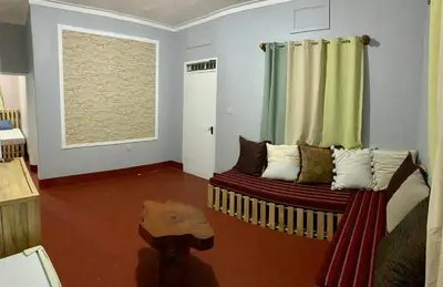a living room with a couch and a window at Pazuri Hostel in Moshi