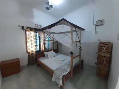 a bedroom with a canopy bed in a room at The Belle View Inn Bed & Breakfast in Moshi