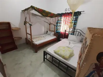 a room with two beds and a tent at The Belle View Inn Bed & Breakfast in Moshi