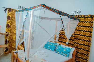 a bed with a canopy in a room at The Belle View Inn Bed & Breakfast in Moshi