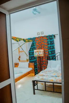 a room with two beds and a glass door at The Belle View Inn Bed & Breakfast in Moshi