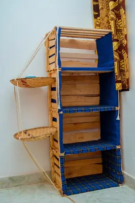 a stack of wooden shelves next to a wall at The Belle View Inn Bed & Breakfast in Moshi