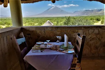 a table with a view of a mountain in the distance at Africa Safari Lake Natron Camping in Mtowabaga