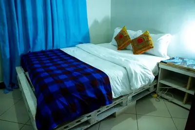 a bed with two pillows on it in a room at New Dream House in Arusha