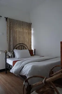 a bedroom with a large bed with a wooden headboard at New Dream House in Arusha