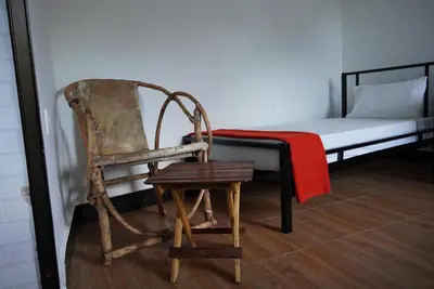 a wooden chair sitting in front of a bed at New Dream House in Arusha