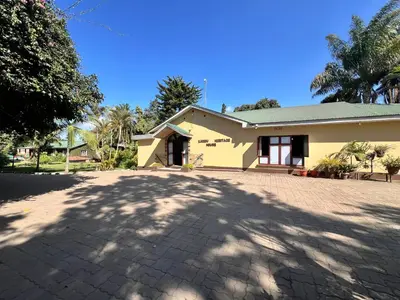 a yellow house with a driveway in front of it at Karibu Heritage House in Arusha