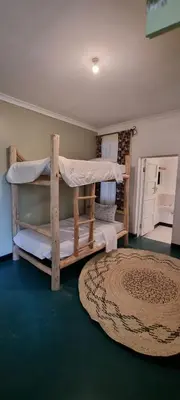 a room with two bunk beds and a rug at Kizumba House in Arusha