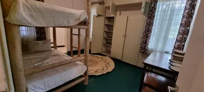 a bedroom with a bunk bed and a room with a window at Kizumba House in Arusha