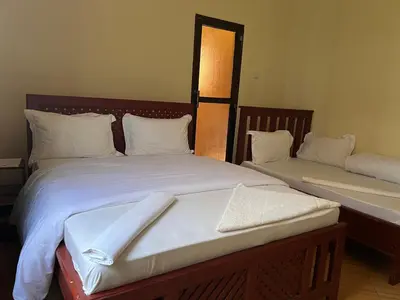 a bedroom with two beds with white sheets and pillows at Johnsons Villas in Zame