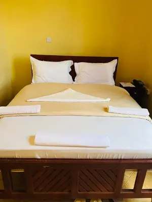 a large bed with two towels on it at Johnsons Villas in Zame