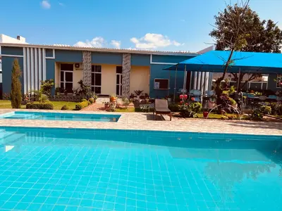 a swimming pool in front of a house at Johnsons Villas in Zame