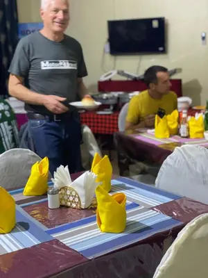 a man standing in front of a table with a plate of food at Johnsons Villas in Zame