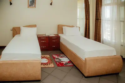 two beds sitting next to each other in a room at seven skies hotel in Arusha