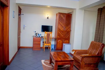 a living room with a couch and a table and a tv at seven skies hotel in Arusha