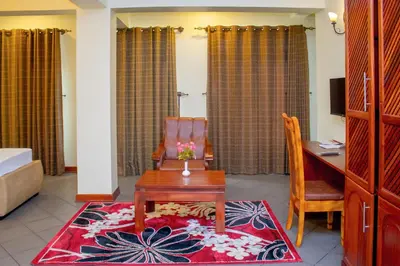a living room with a desk and a chair and a table at seven skies hotel in Arusha