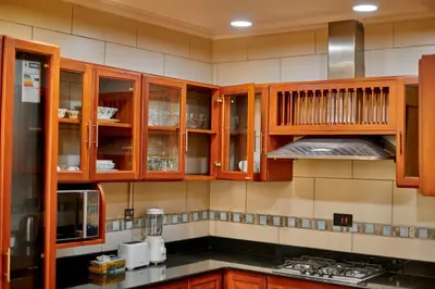 a kitchen with wooden cabinets and a counter top at seven skies hotel in Arusha