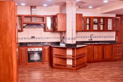 a kitchen with wooden cabinets and a stove top oven at seven skies hotel in Arusha