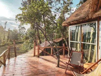 a wooden deck with a chair on a house at Foresight Eco Lodge & Safari in Karatu