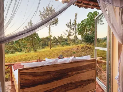 a bed in a room with a large window at Foresight Eco Lodge & Safari in Karatu