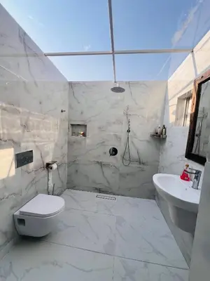 a white bathroom with a toilet and a sink at City Retreat Arusha in Arusha