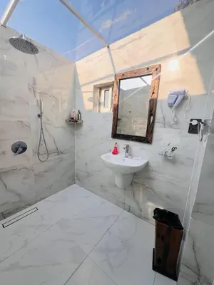 a white bathroom with a sink and a mirror at City Retreat Arusha in Arusha