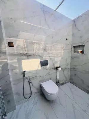 a white bathroom with a toilet and a sink at City Retreat Arusha in Arusha