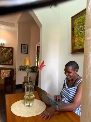 a woman sitting at a table using a laptop computer at Sophie Homestay in Moshi