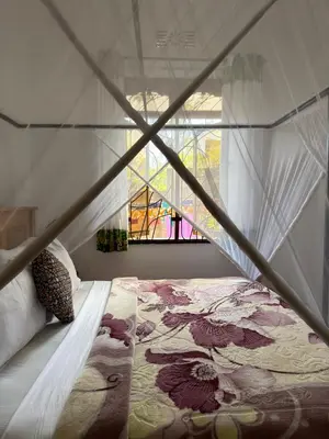 a bedroom with a bed and a window at Sophie Homestay in Moshi