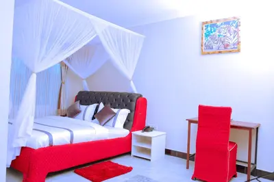 a bedroom with a red bed and a red chair at Elanacha Hotel in Arusha